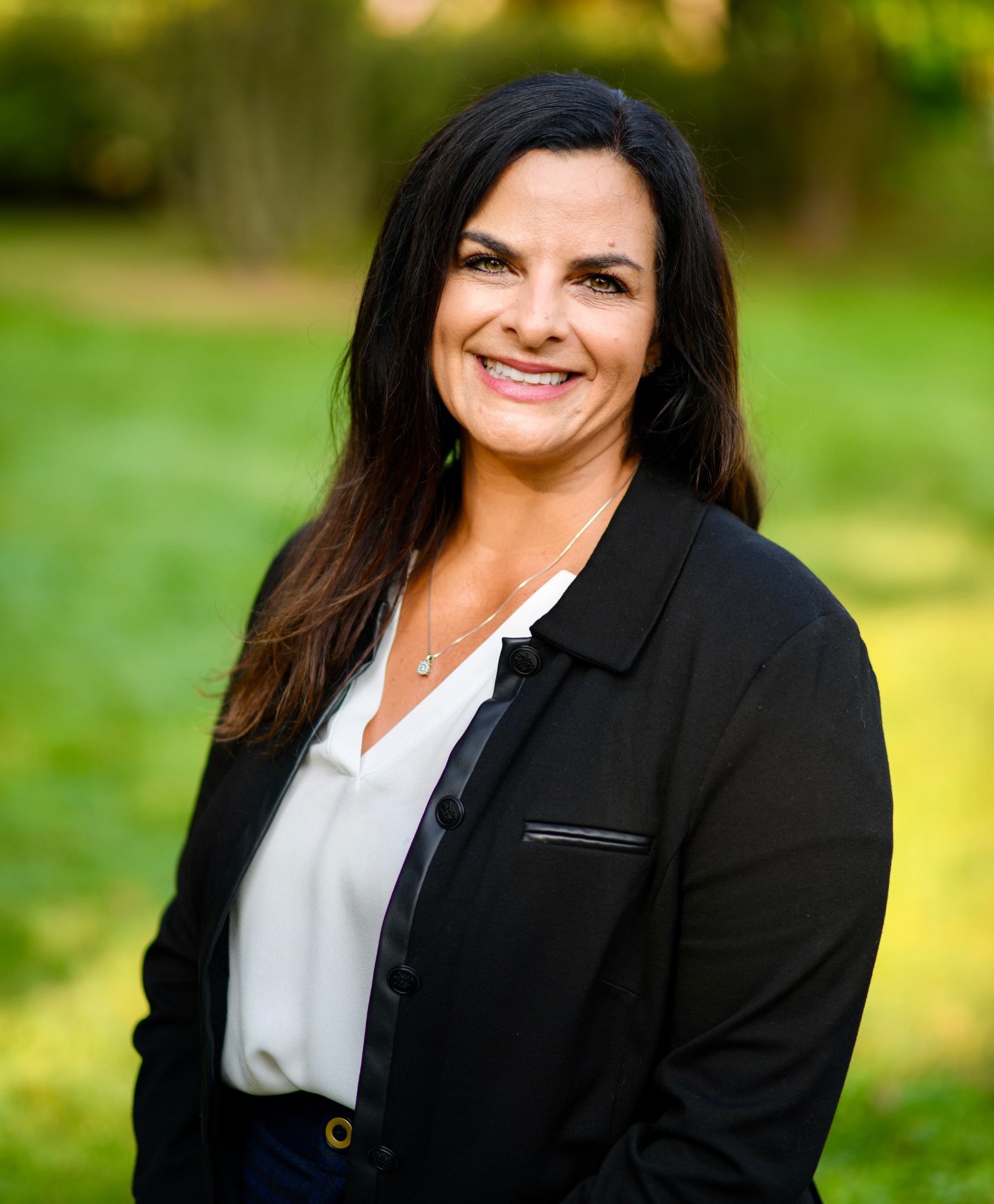Photo of Dana Hebreard, a smiling woman wearing a print blouse and a black jacket
